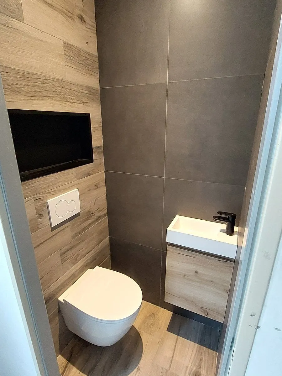 Wc met houtlookwand en zwarte nis in Assen — toiletrenovatie door BontBouw