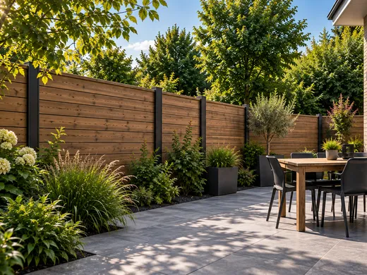 Houten schutting met zwarte palen langs een terras in een tuin in Groningen